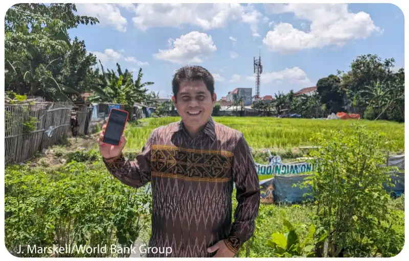 Lady using a mobile phone to pay at a vegetable market